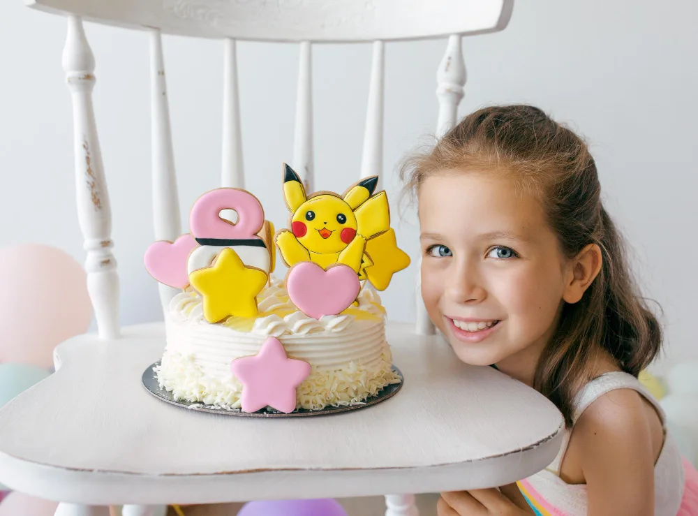 Girl with birthday cake with her favorite Pokemon.
